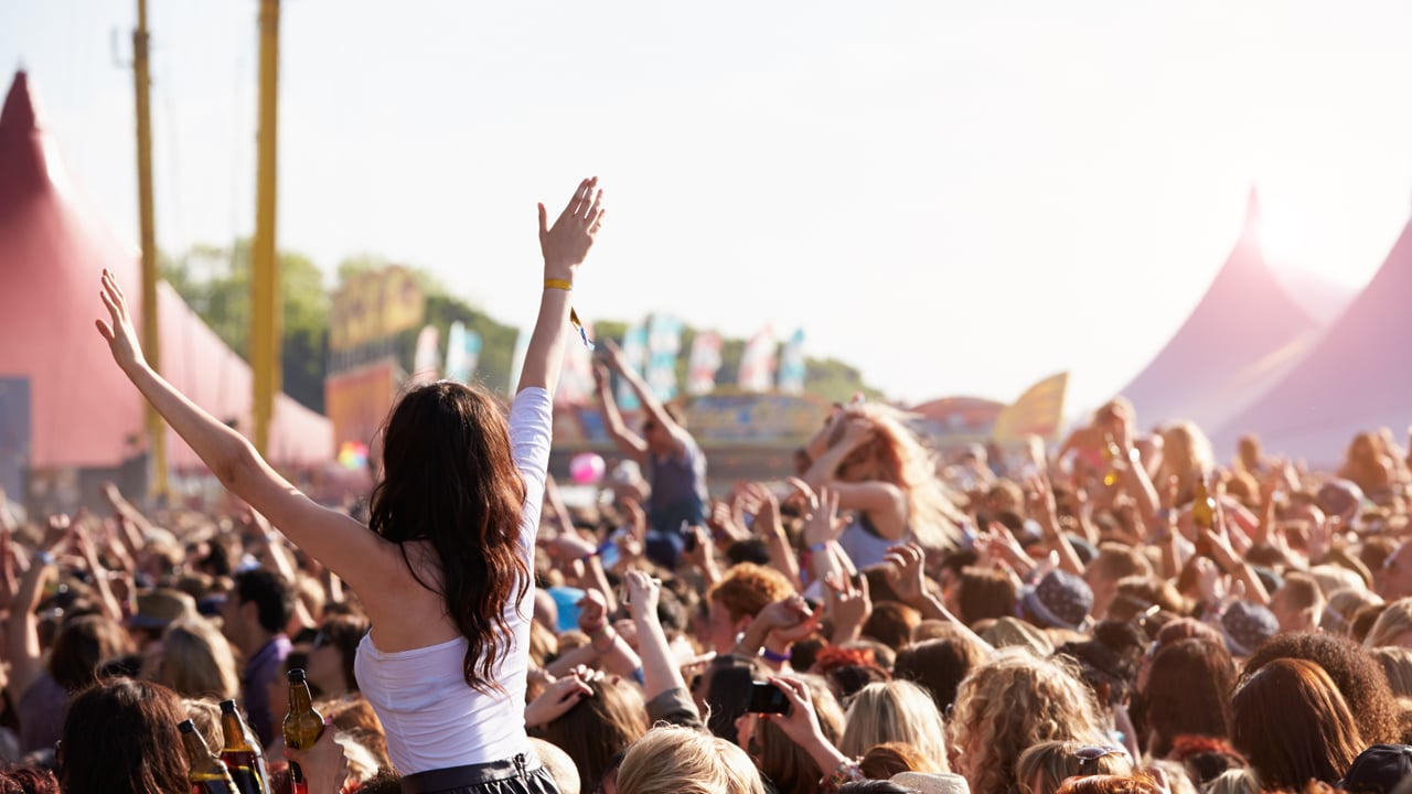 Girls on shoulders in crowd at music festival