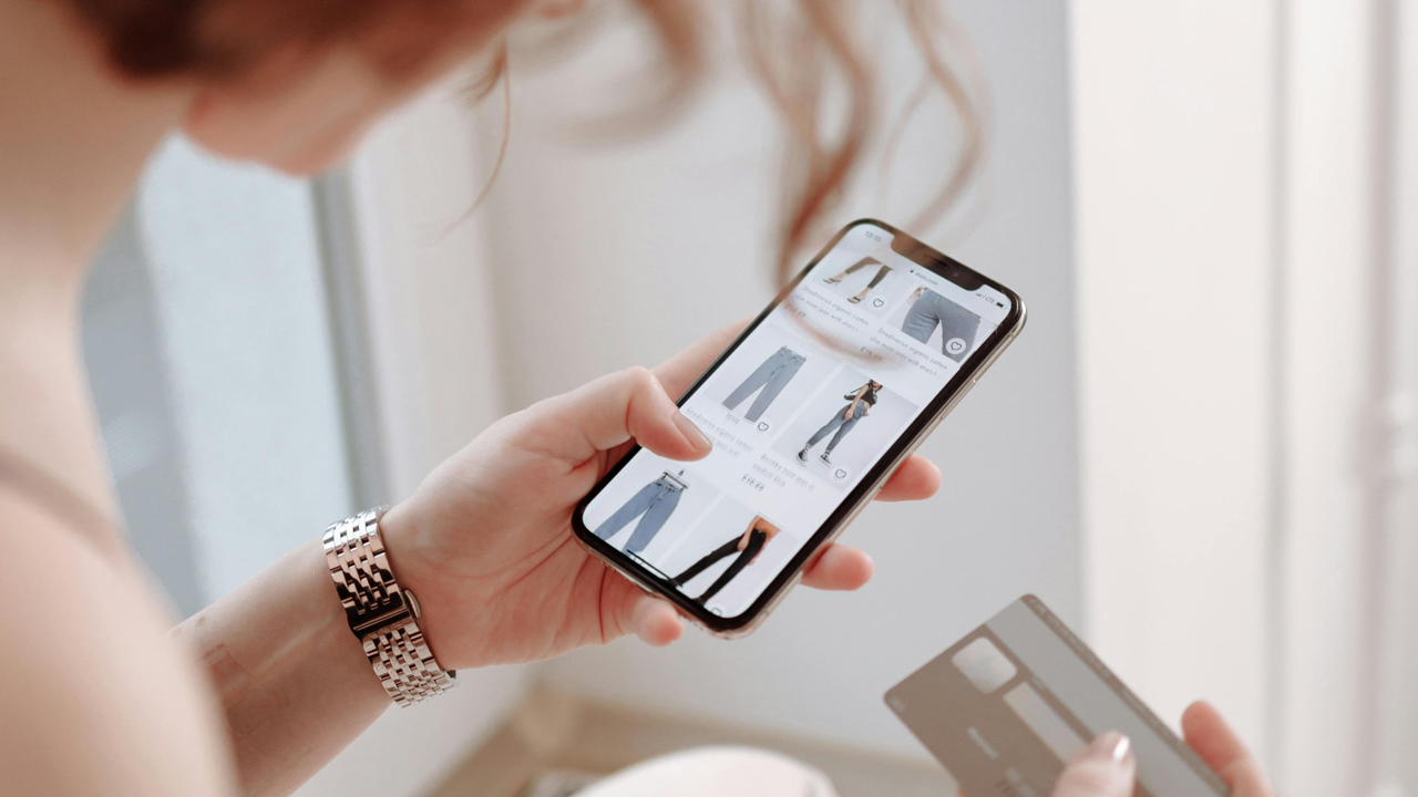 Woman scrolling through online clothing store on her phone screen
